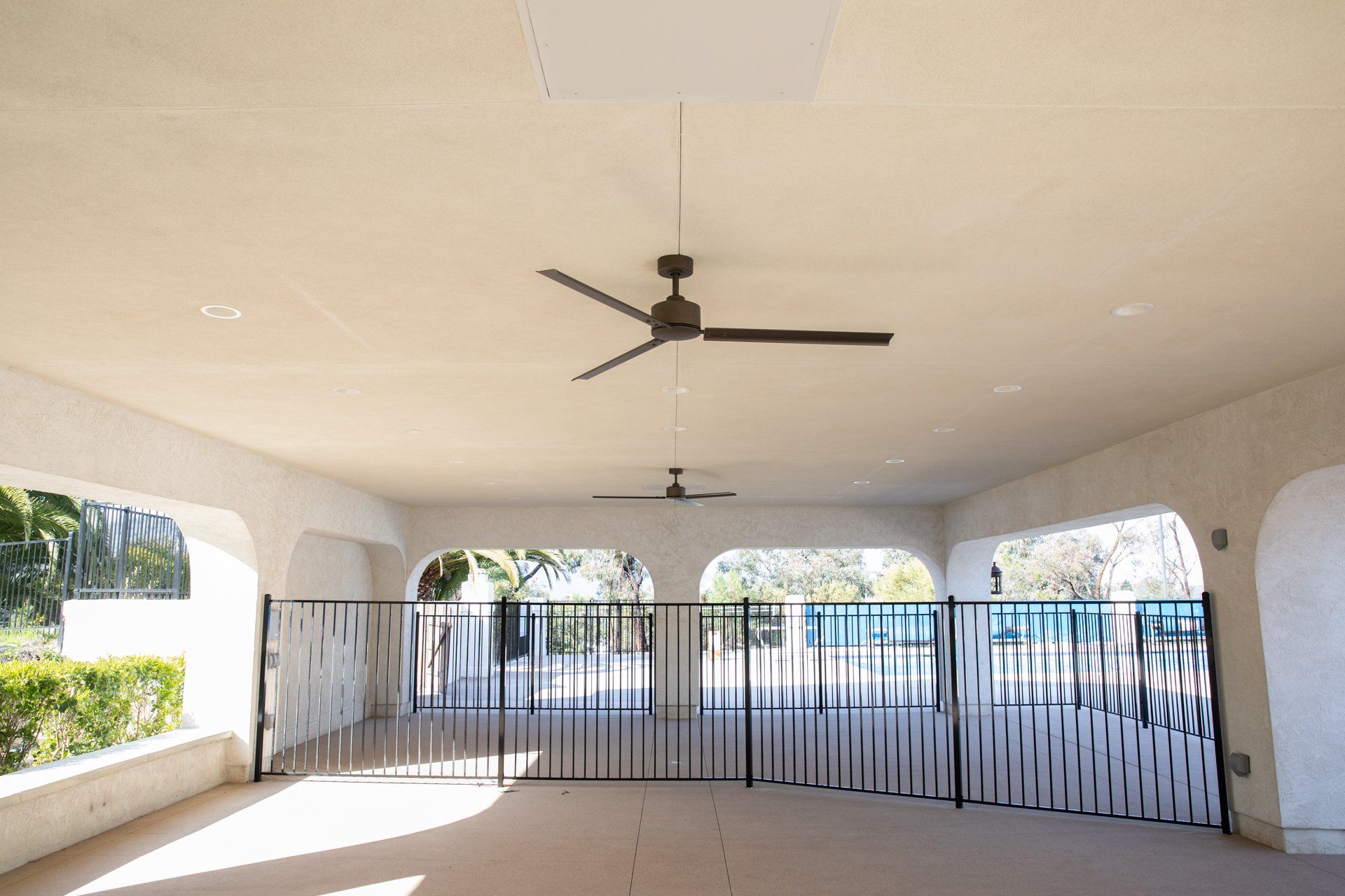 An empty room with a ceiling fan hanging from the ceiling