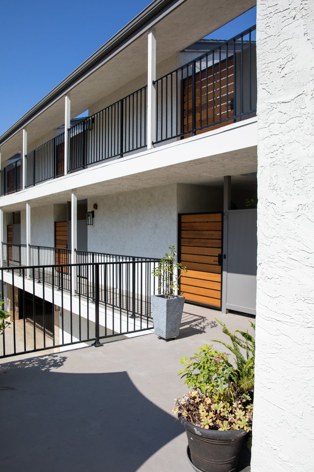 A balcony of a building with a fence and potted plants