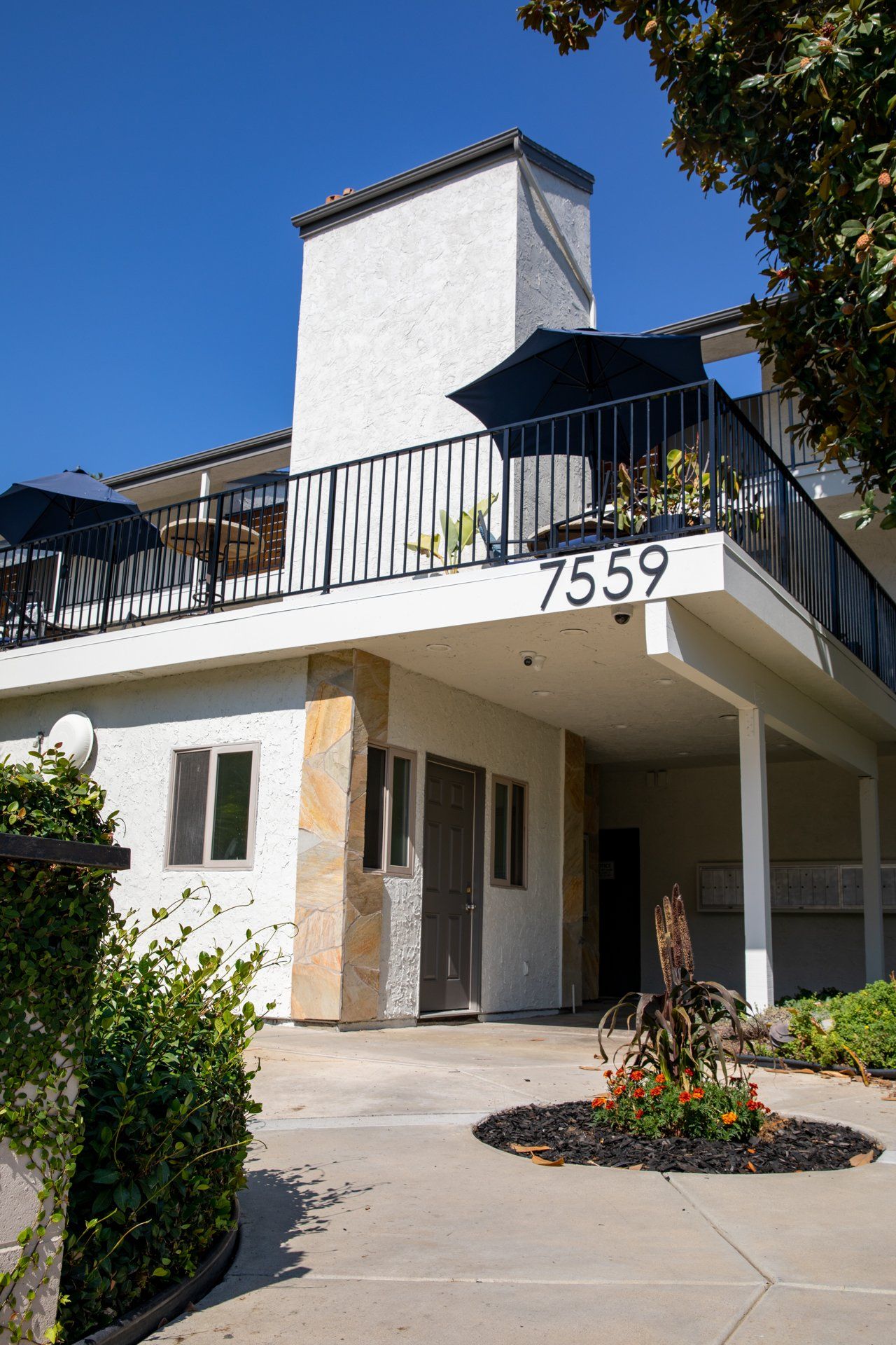 A large white house with a balcony and a sign that says 7559