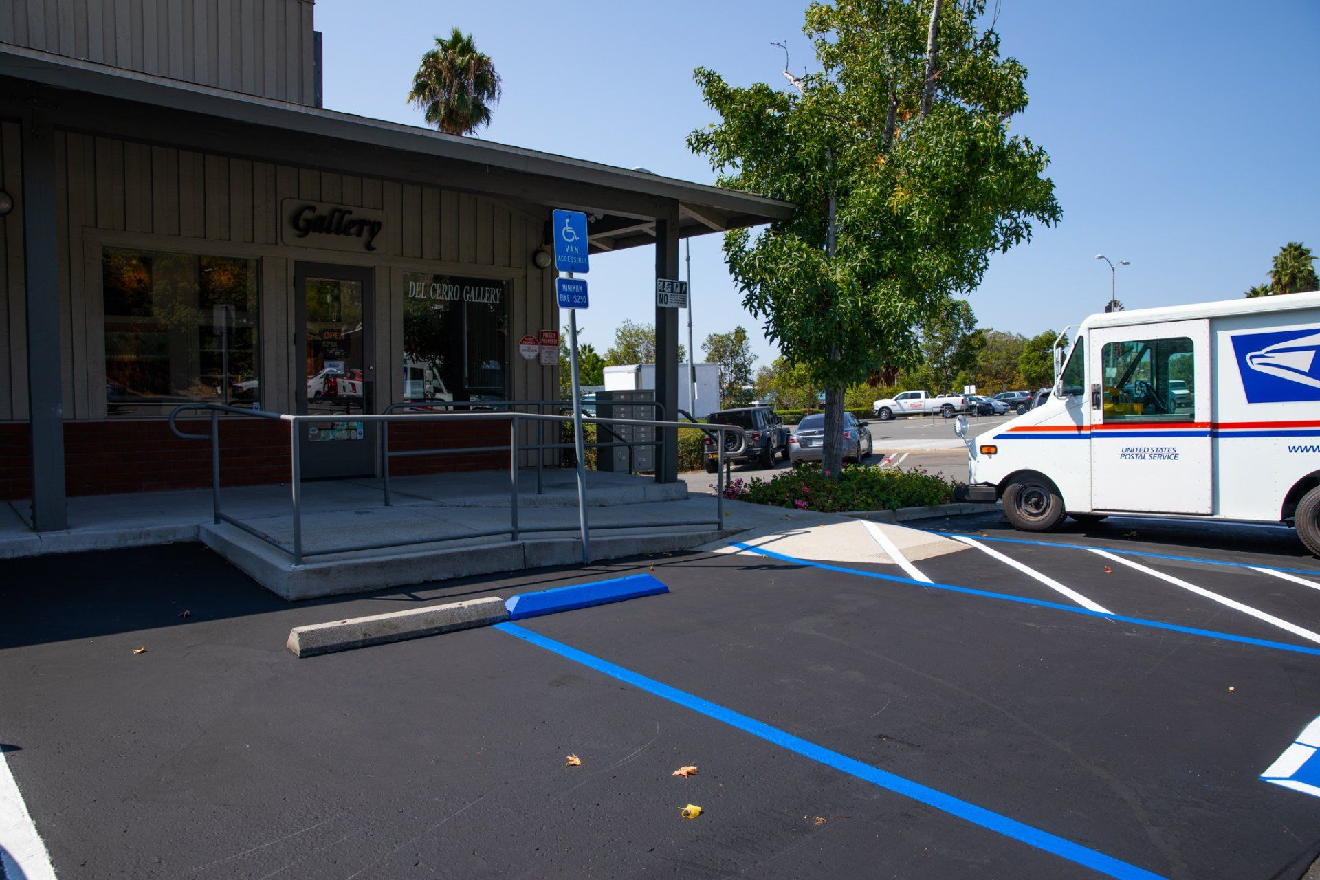 A mail truck is parked in front of a gallery