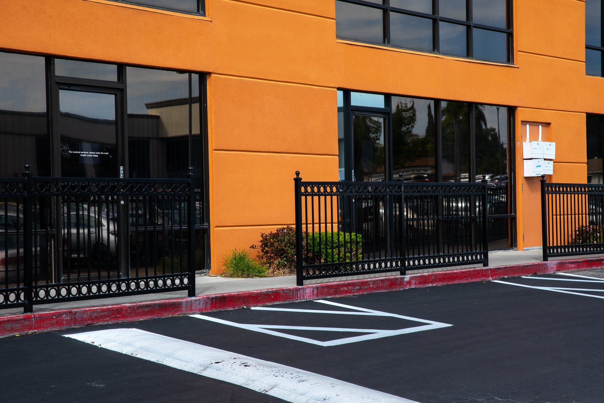 A parking lot in front of a large orange building