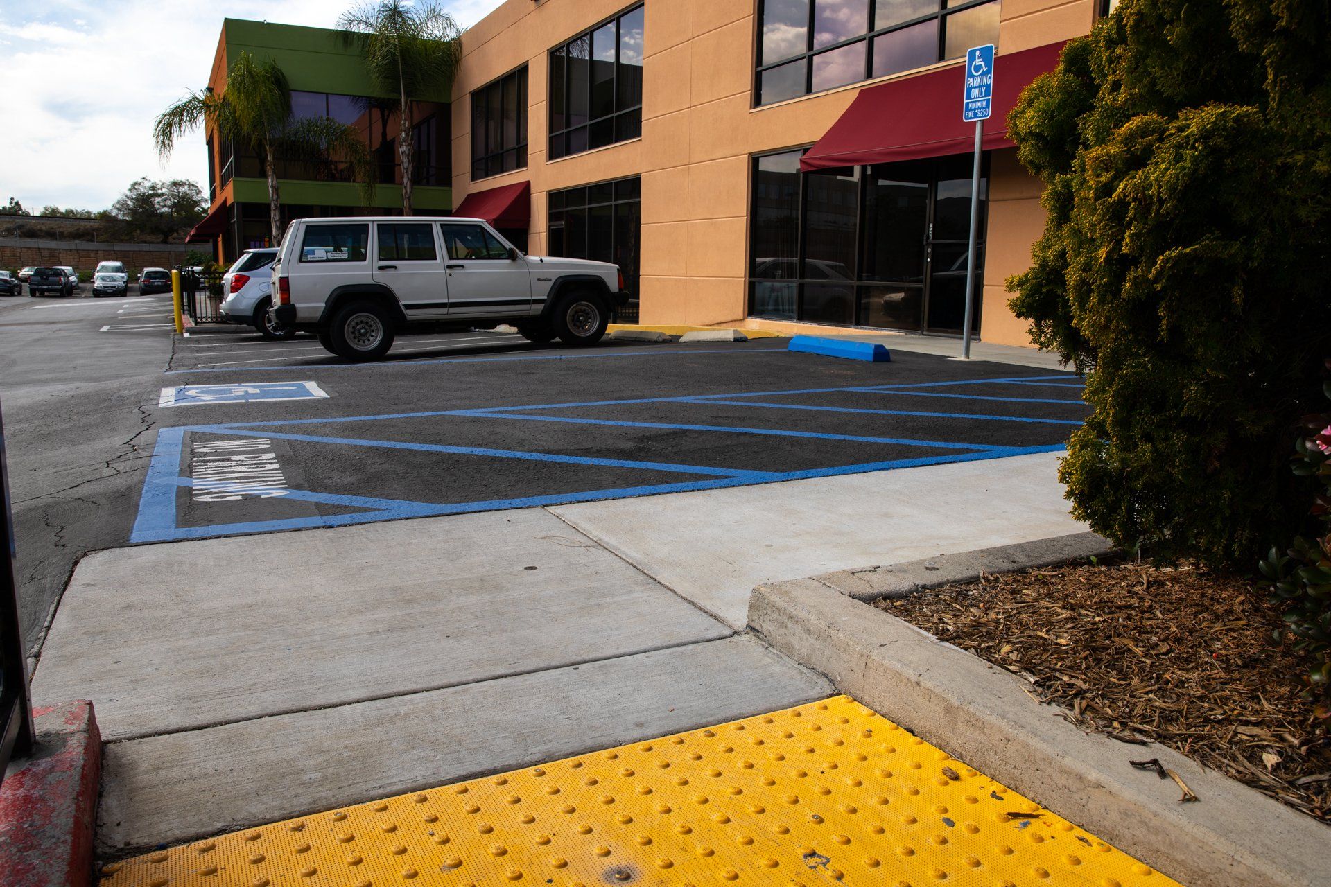 A white suv is parked in a handicapped parking spot