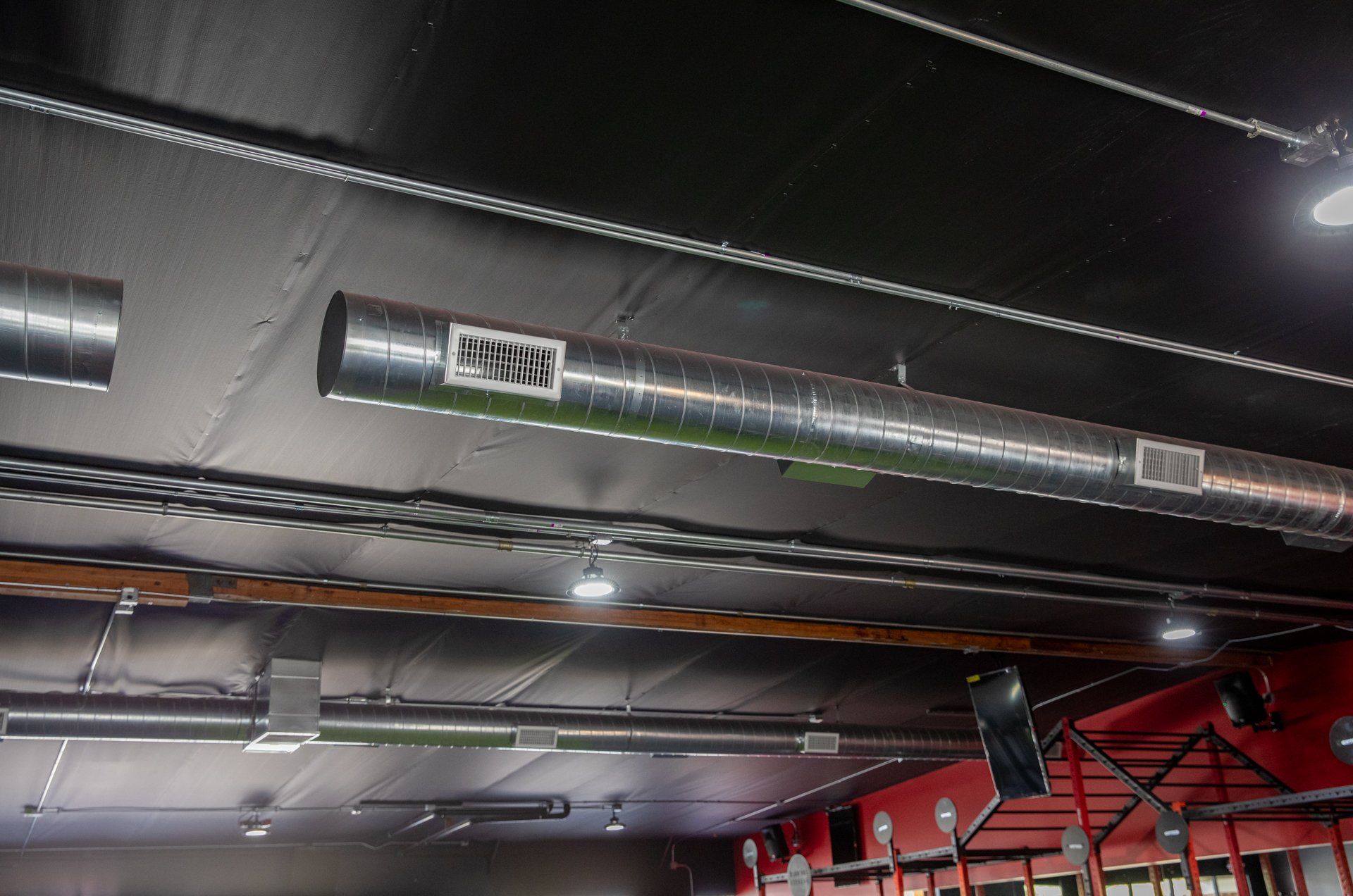 A ceiling with a lot of pipes hanging from it.