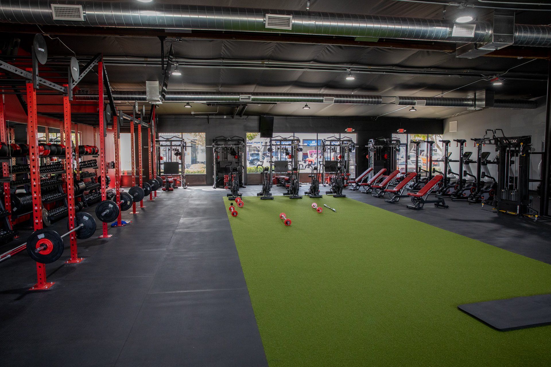 A large gym with a lot of equipment and a green carpet.