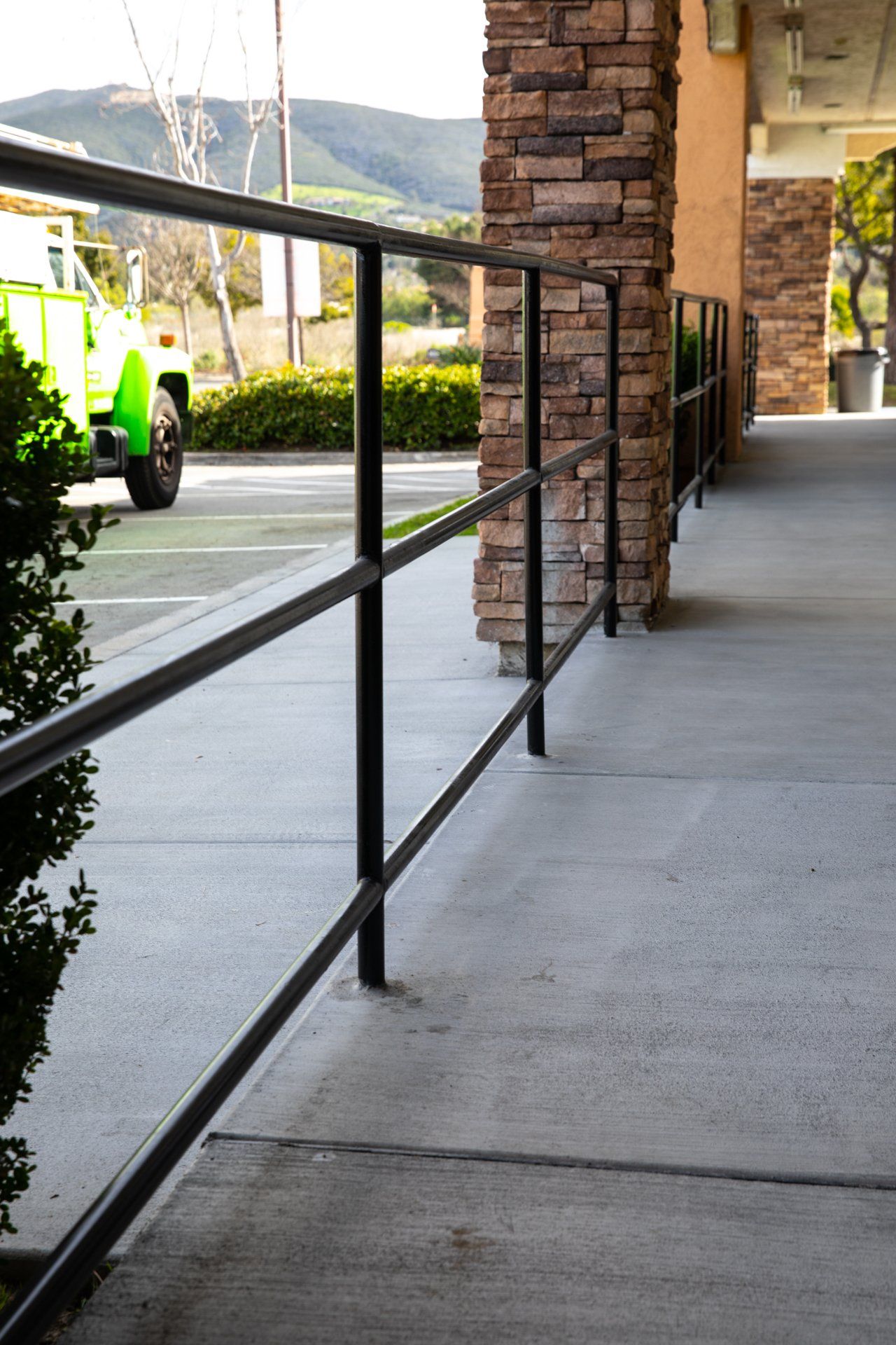 A green truck is parked on the side of the road