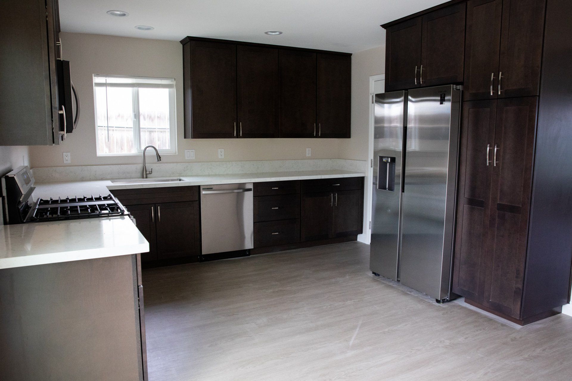 A kitchen with stainless steel appliances and brown cabinets