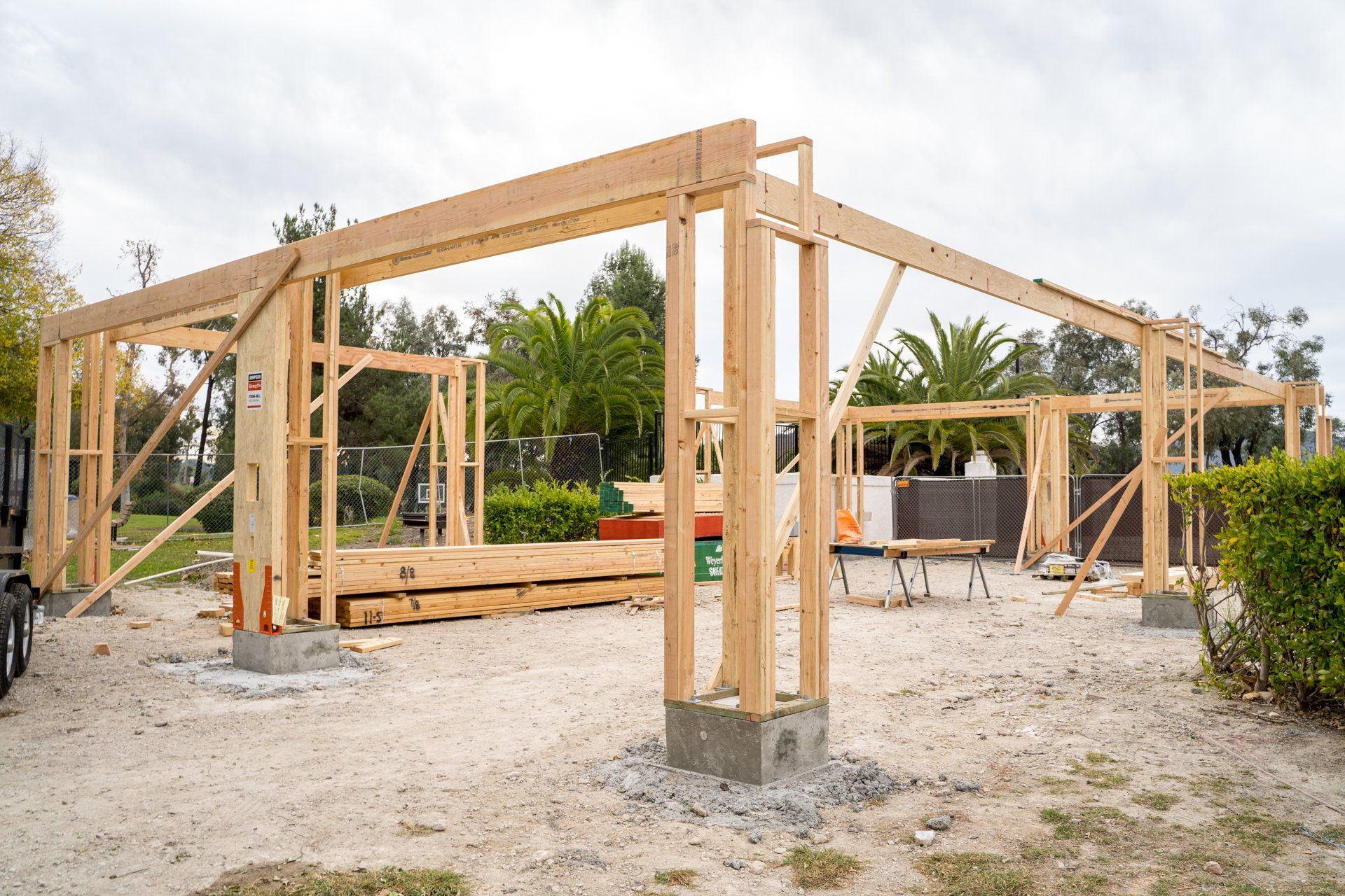 A wooden structure is being built in a dirt field.