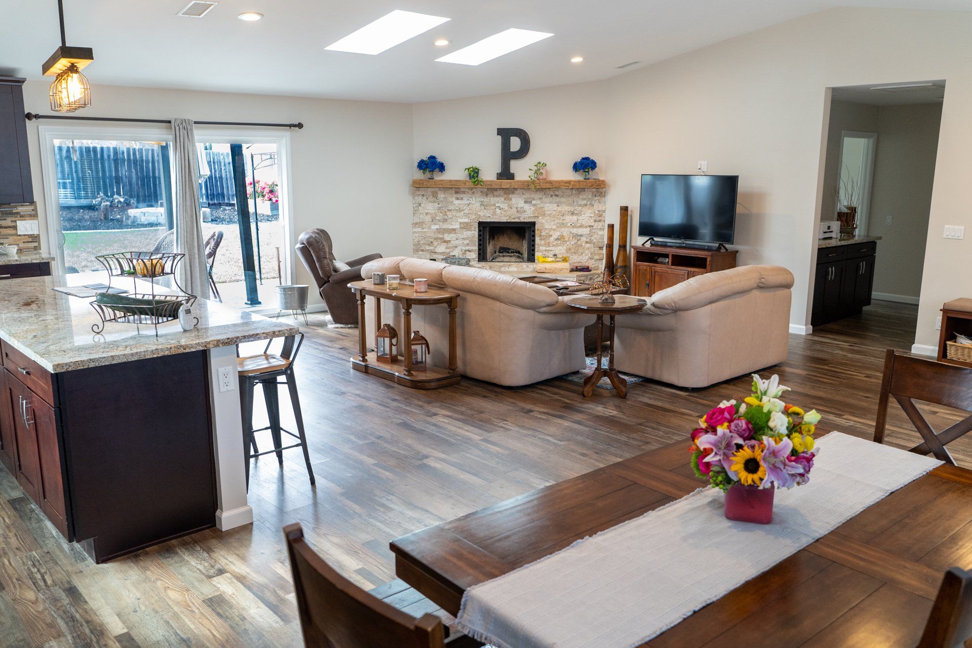 A living room with a dining table and chairs and a fireplace.