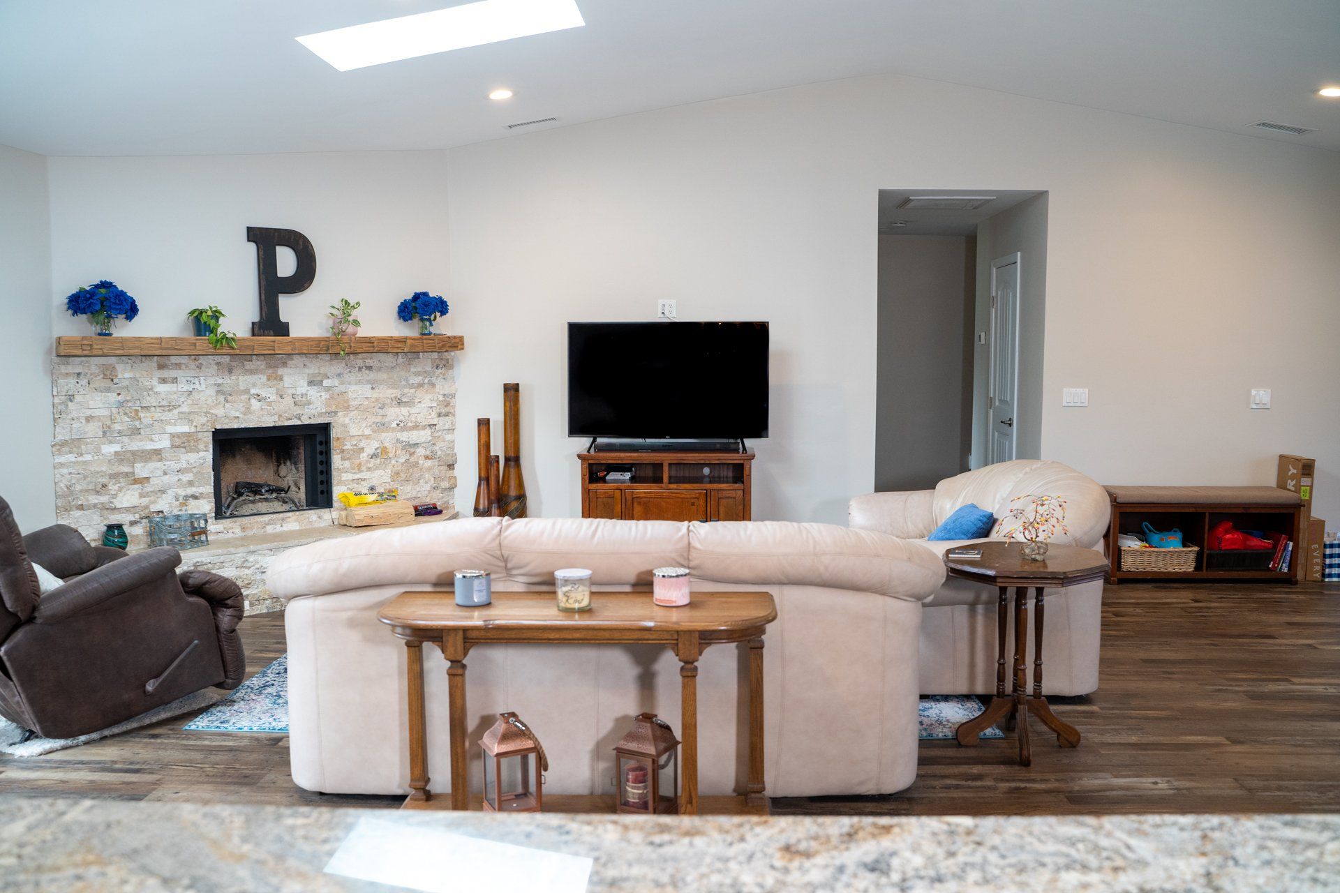 A living room with a couch , television , and fireplace.
