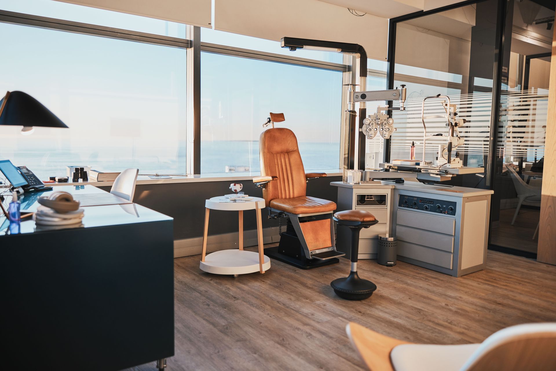 A dental office with a chair and a desk with a view of the ocean.