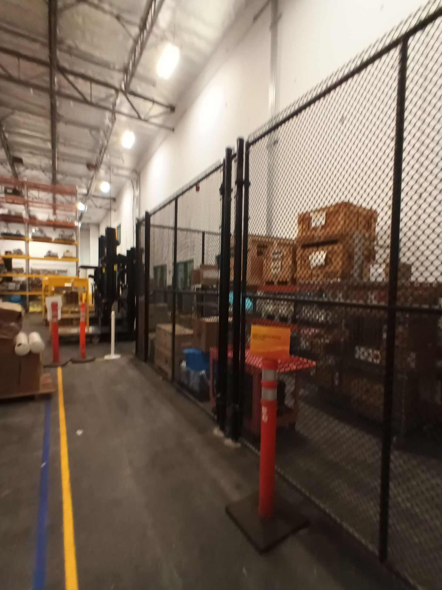 A warehouse with a chain link fence surrounding it