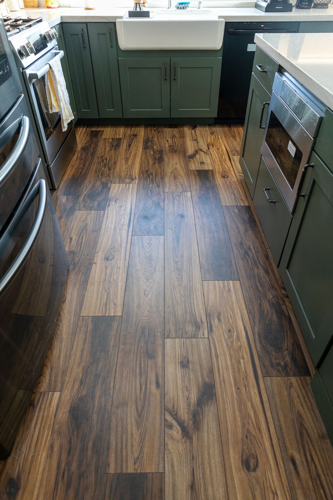 A kitchen with a wooden floor and green cabinets