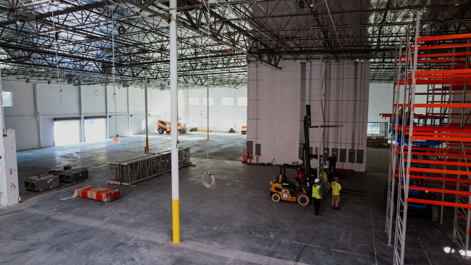 A large warehouse with a forklift in the middle of it.