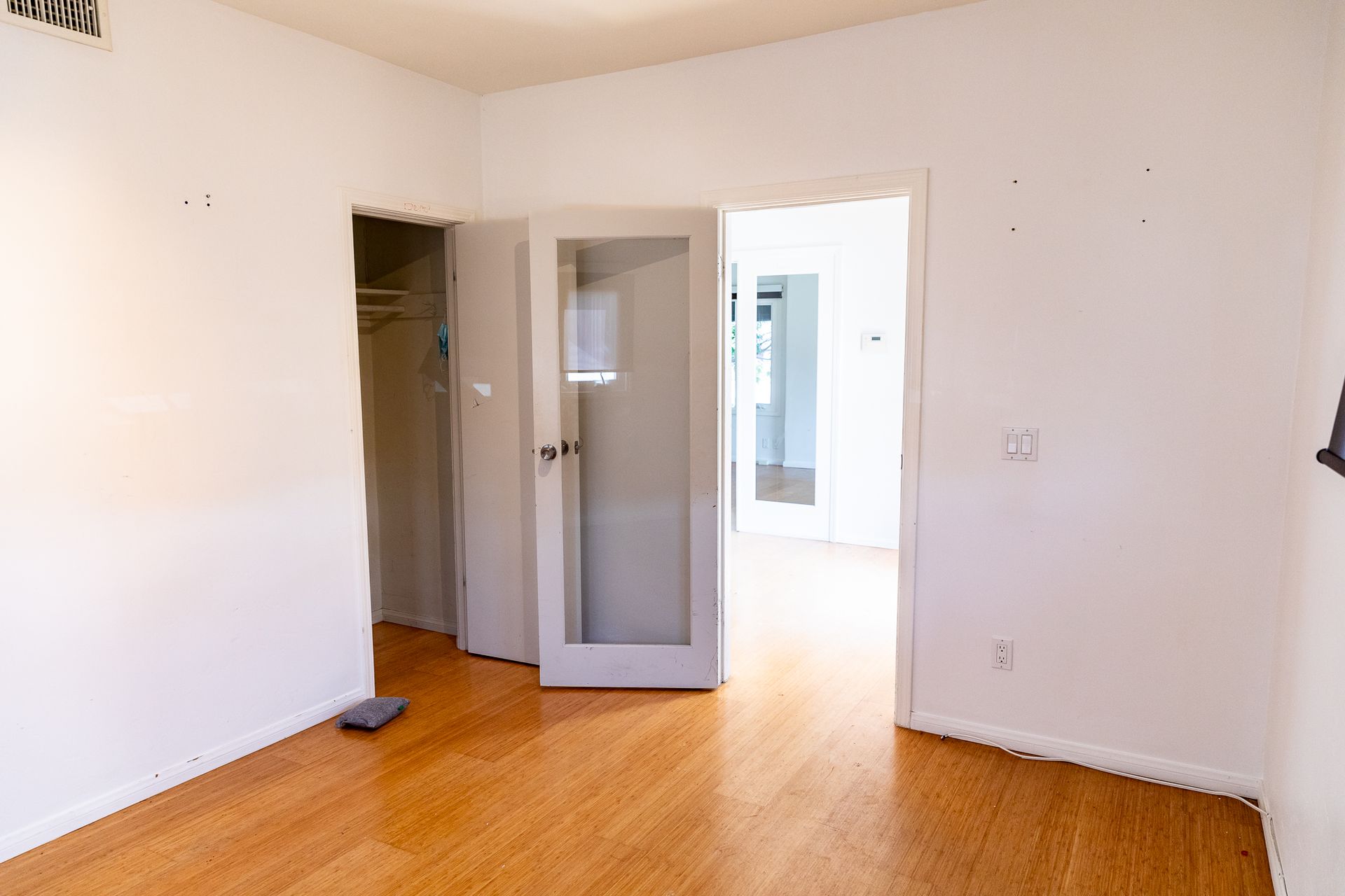 An empty room with hardwood floors and white walls.