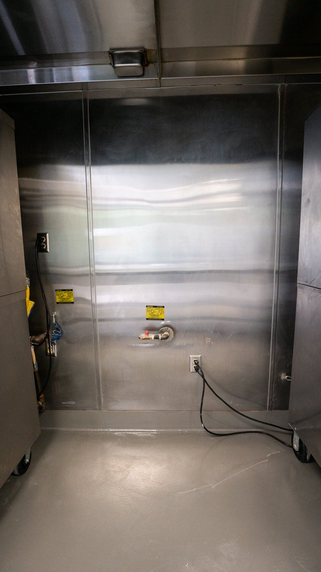 There is a stainless steel door in the middle of the room.