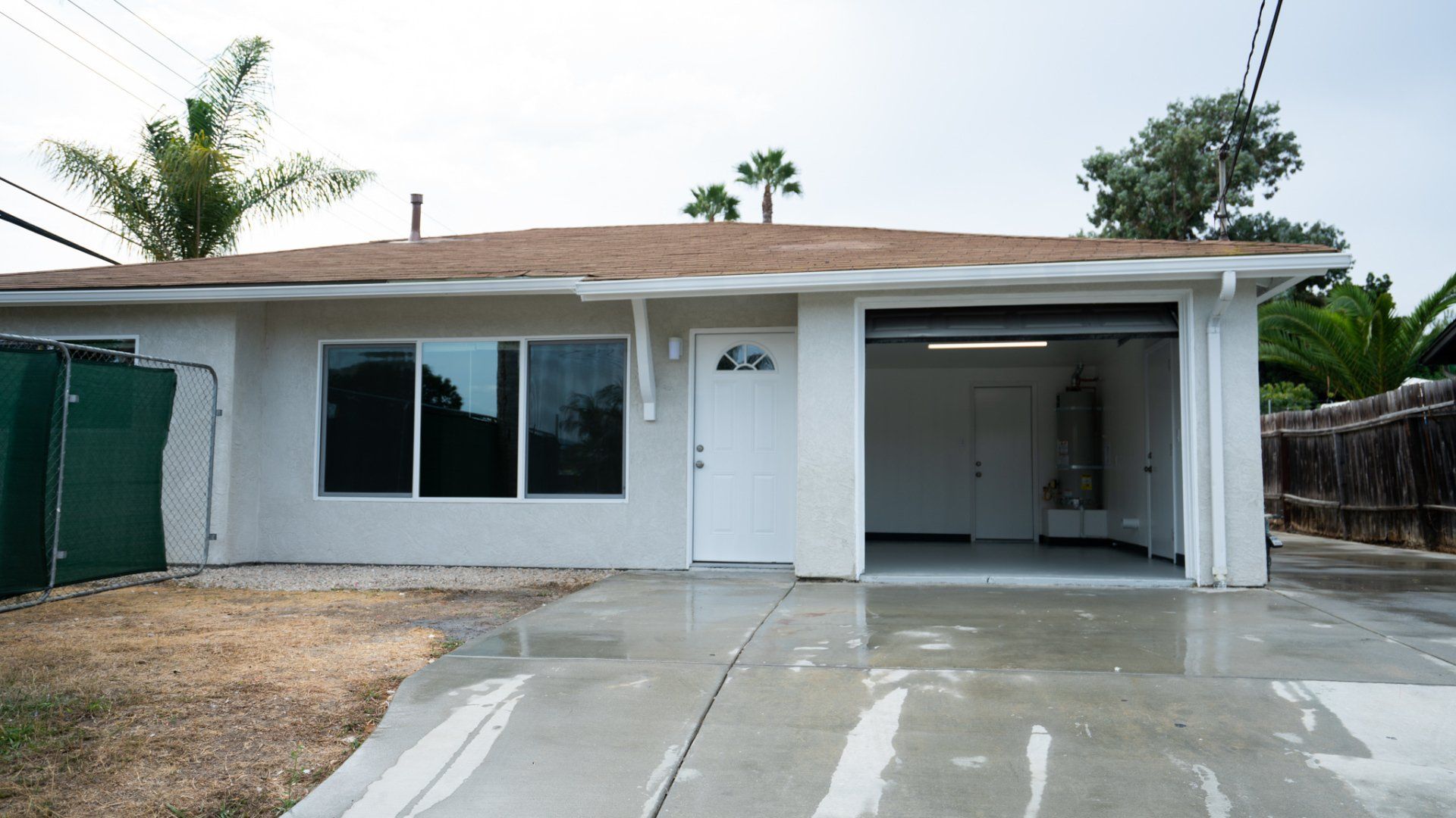 A white house with a brown roof and a garage