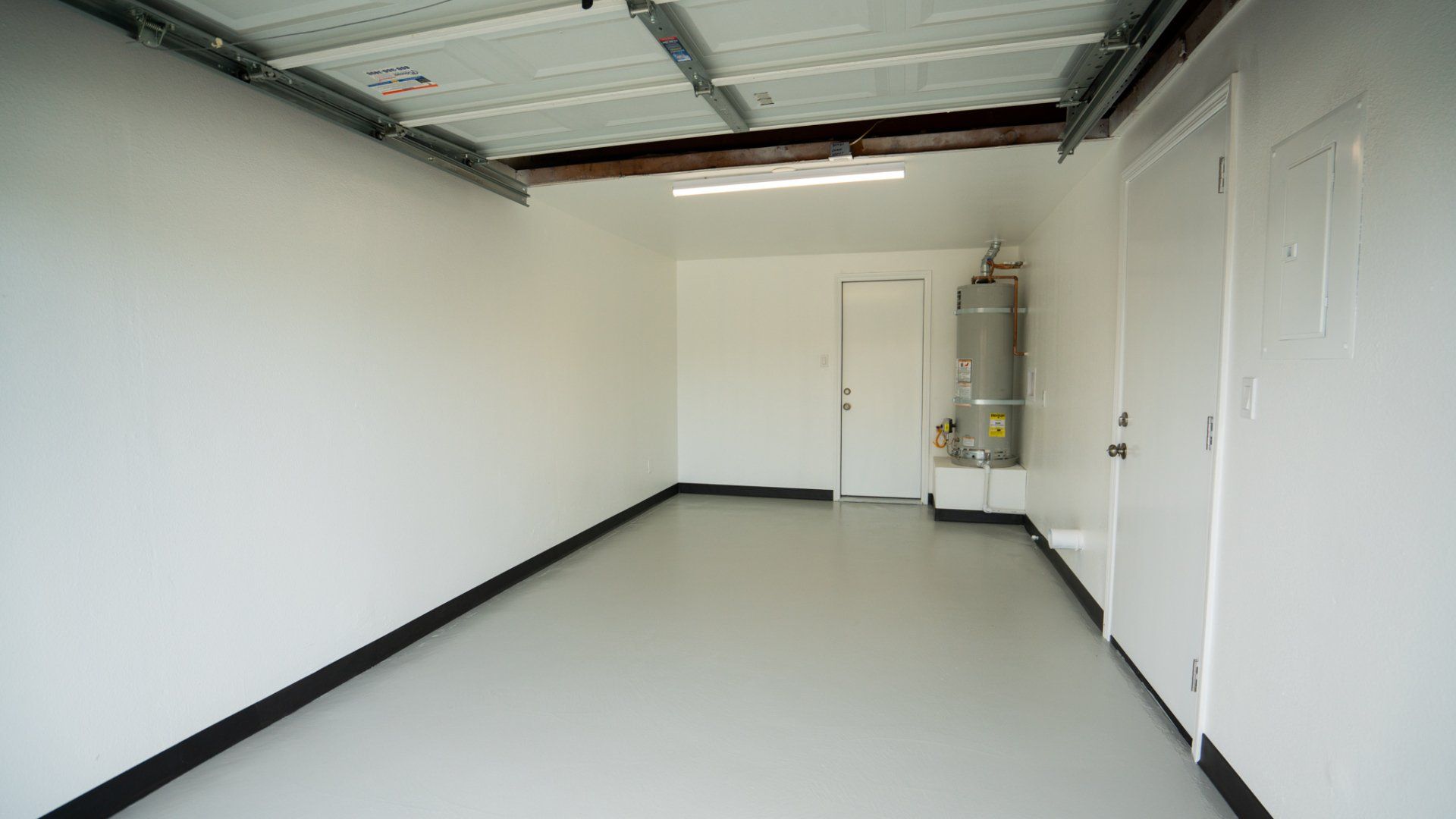 An empty garage with white walls and black trim