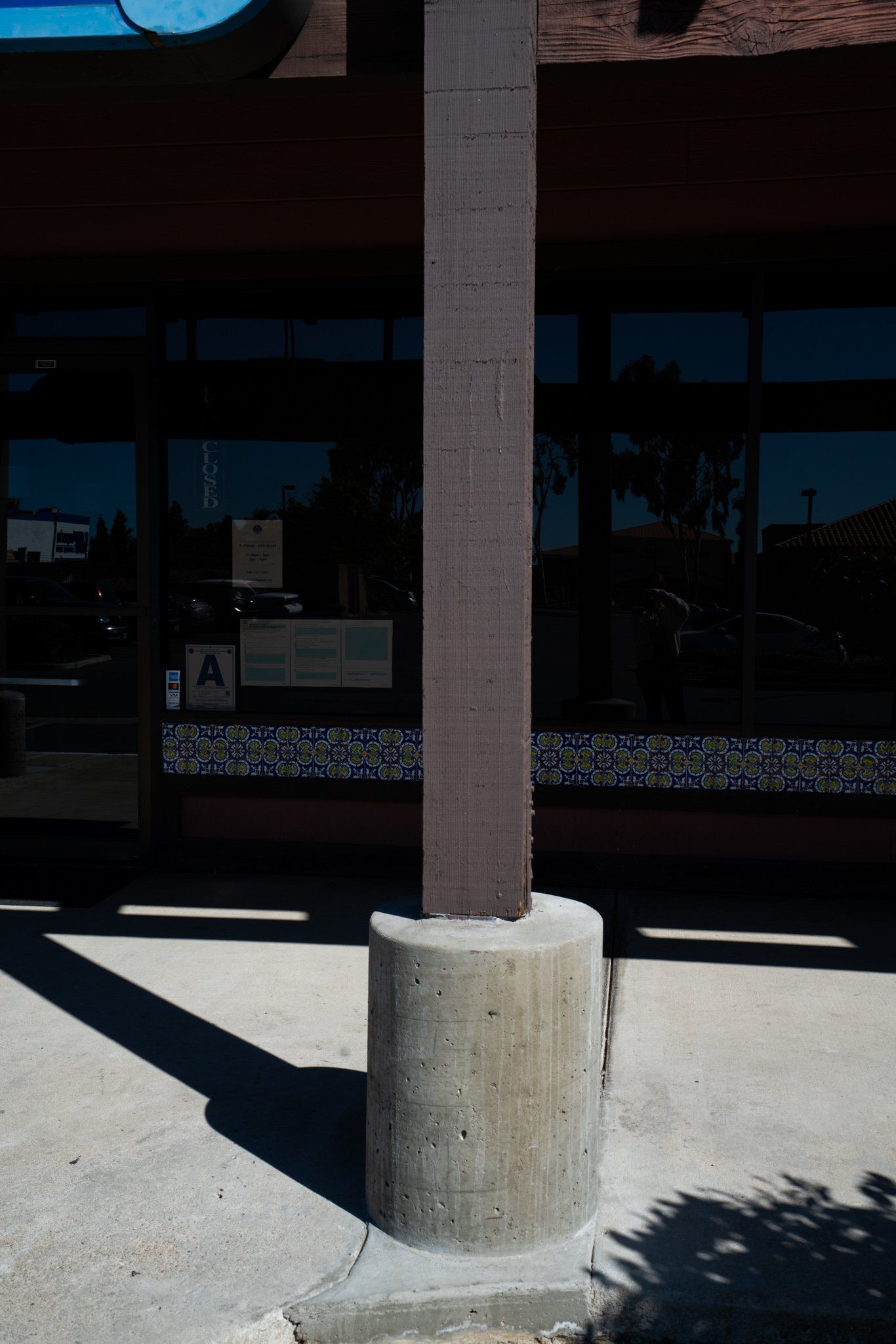 A concrete pole is sitting in front of a building.