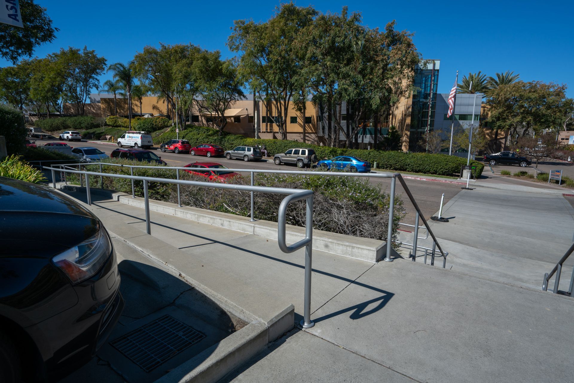 A car is parked on the side of the road next to a railing