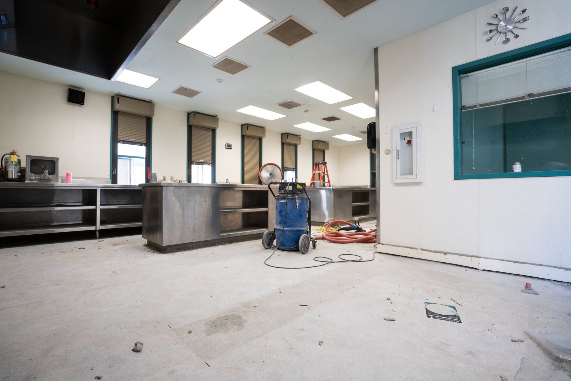 An empty room with a vacuum cleaner in the middle of it