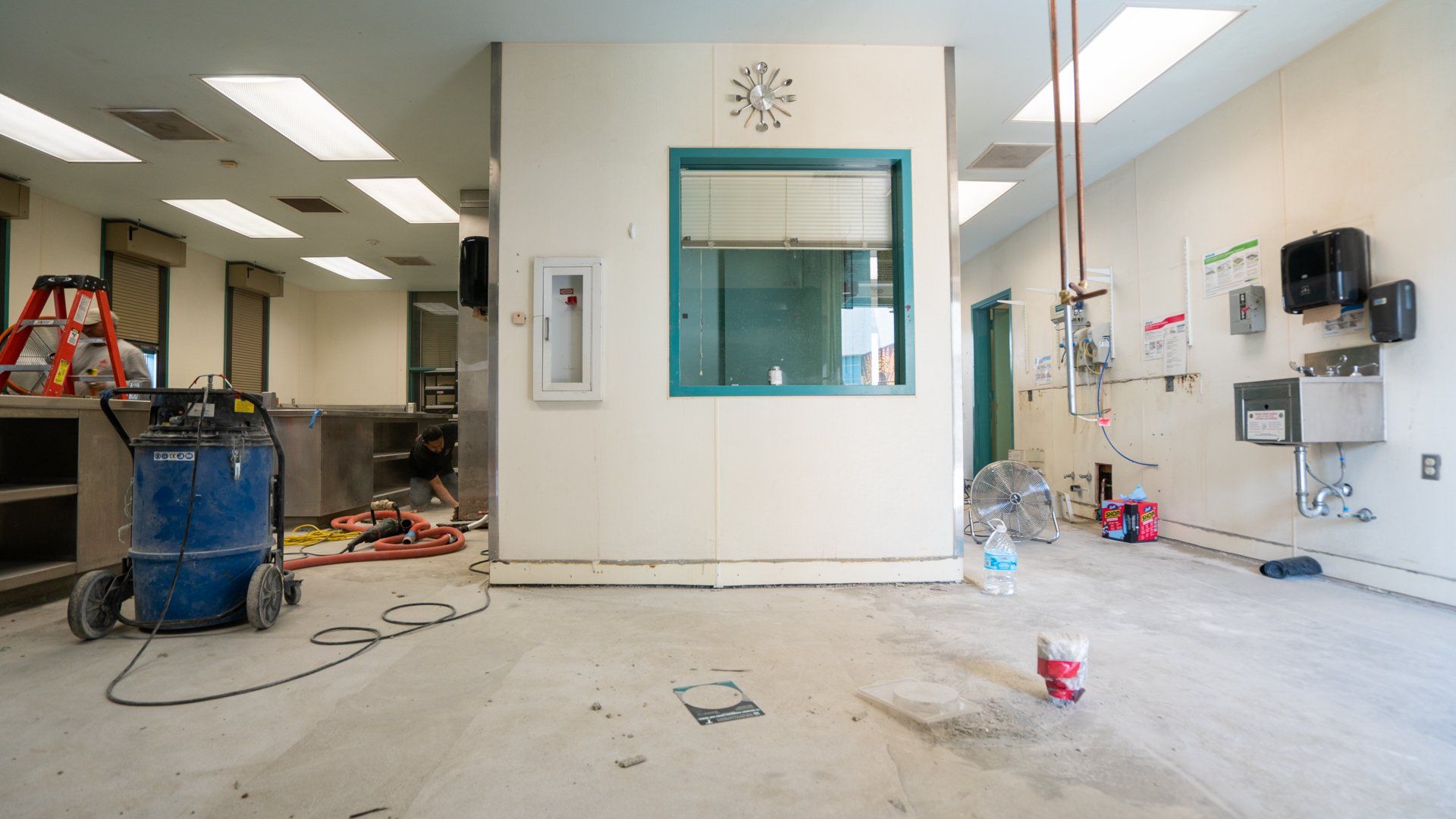 An empty room with a clock on the wall and a window.