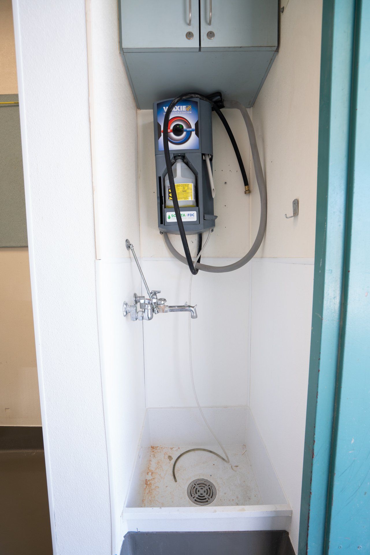 A bathroom with a sink and a faucet on the wall.