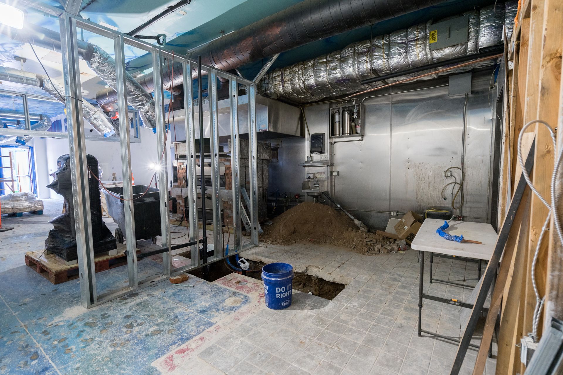 A blue bucket with the number 13 on it sits in a hole in the floor