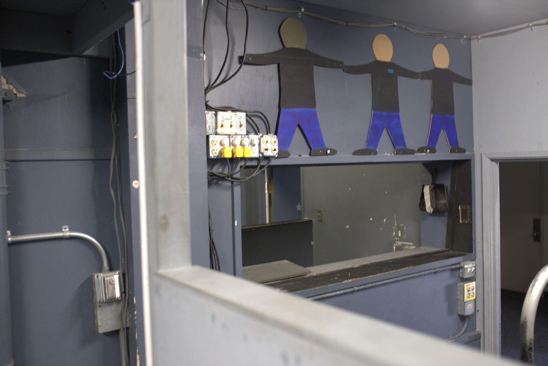 A room with a shelf with three people on it