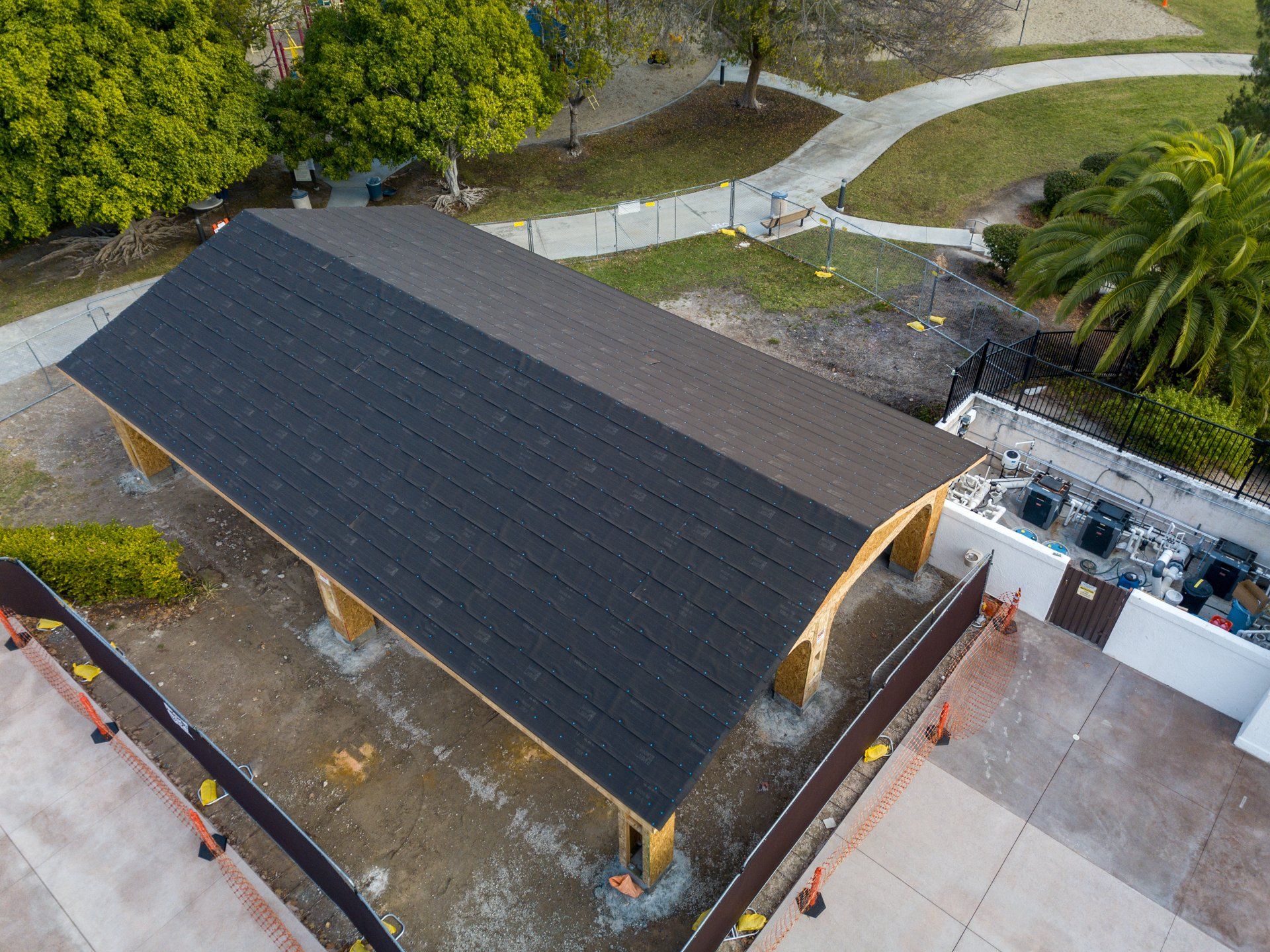 An aerial view of a building under construction with a black roof.