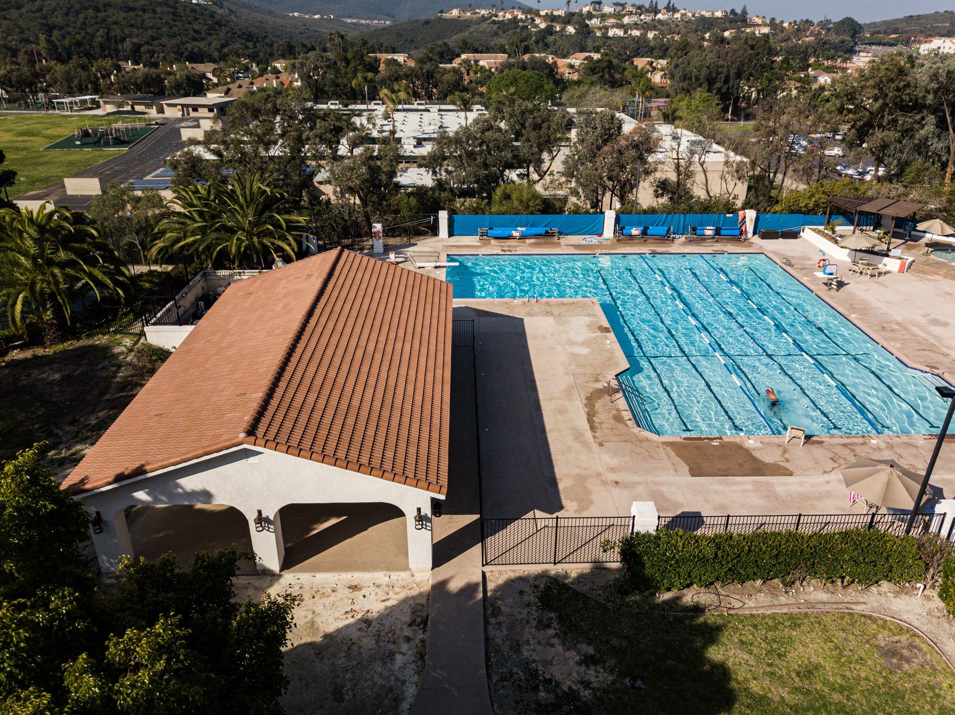 An aerial view of a large swimming pool with a building in the foreground.