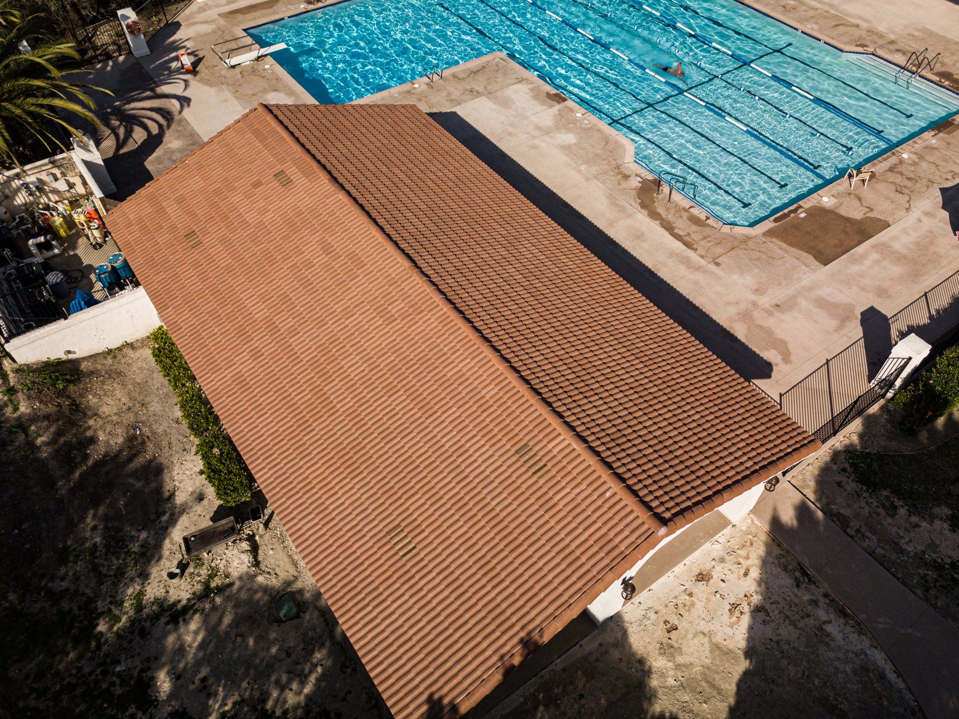 An aerial view of a swimming pool with a house in the foreground