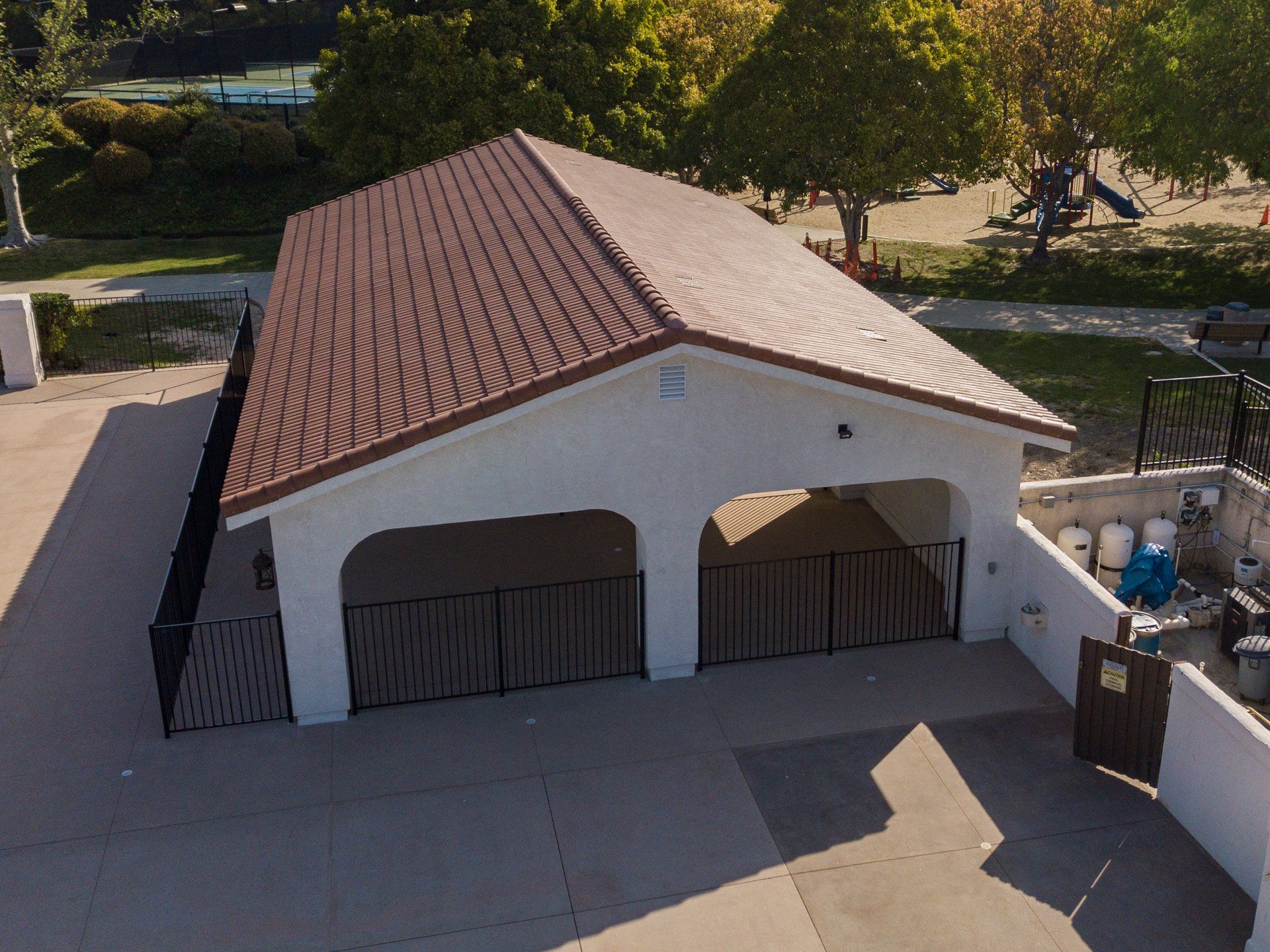 An aerial view of a white building with a brown roof