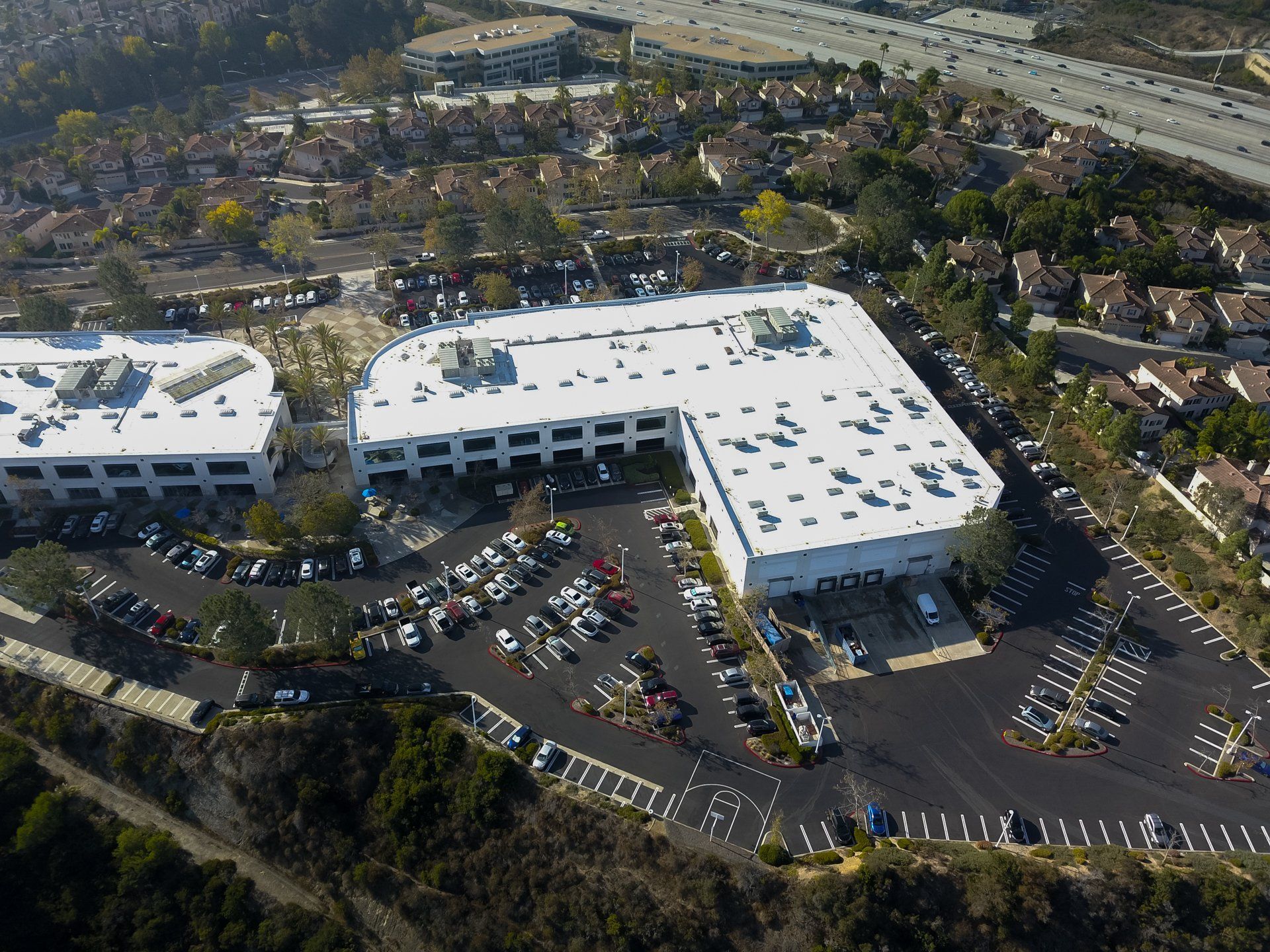 An aerial view of a large building with a white roof