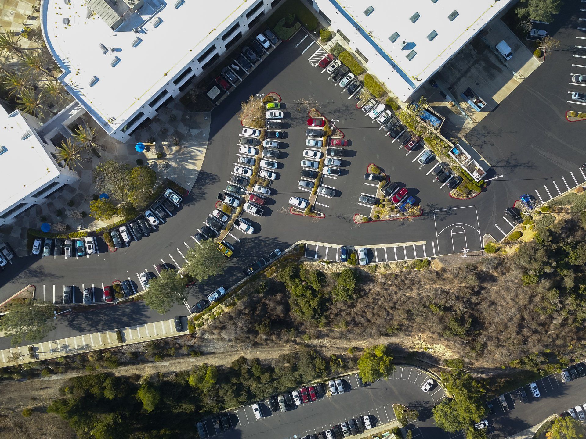 An aerial view of a parking lot with lots of cars parked