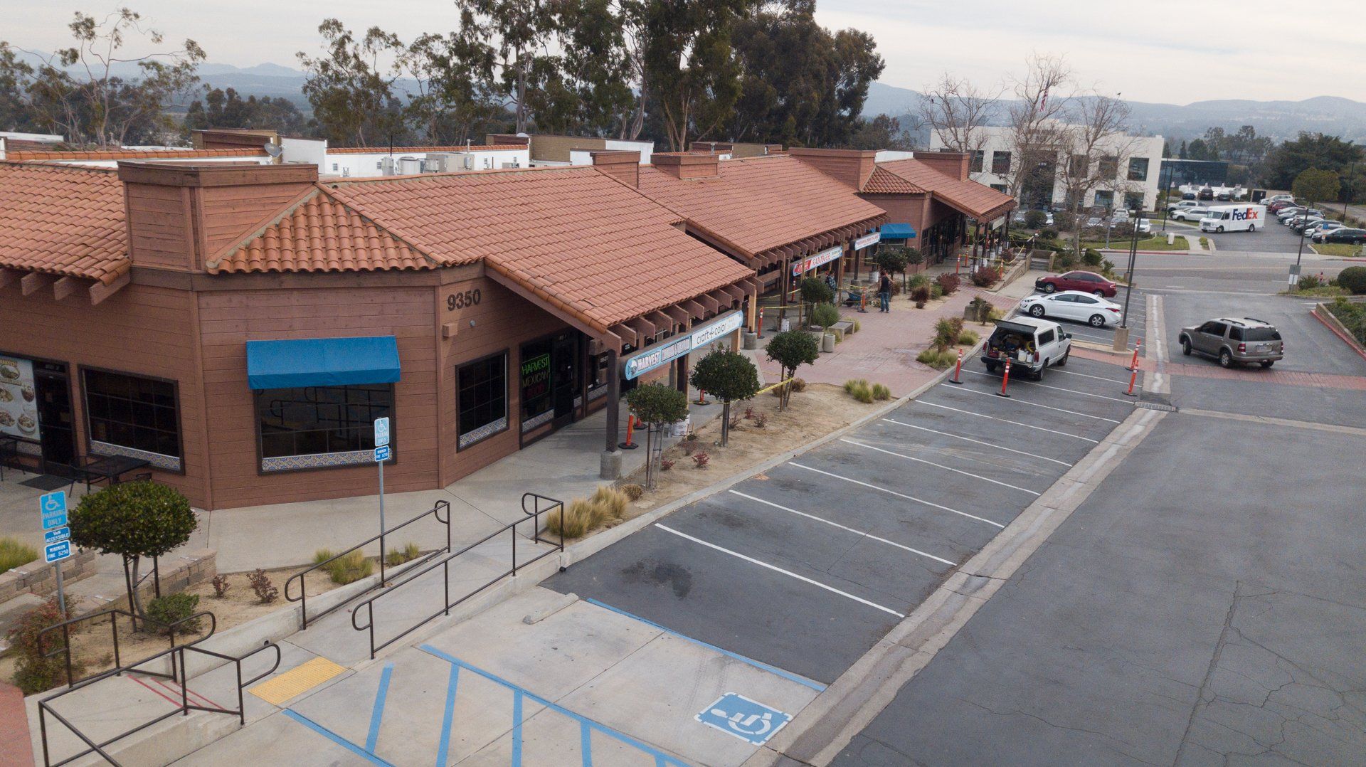 An aerial view of a parking lot in front of a building.