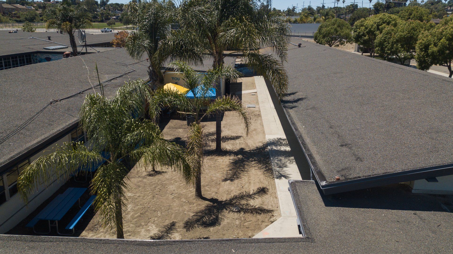 An aerial view of a building with palm trees