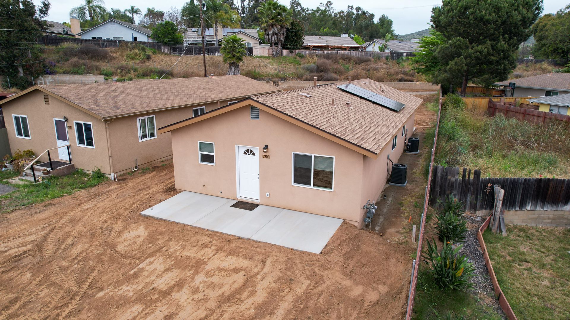 An aerial view of a house with solar panels on the roof