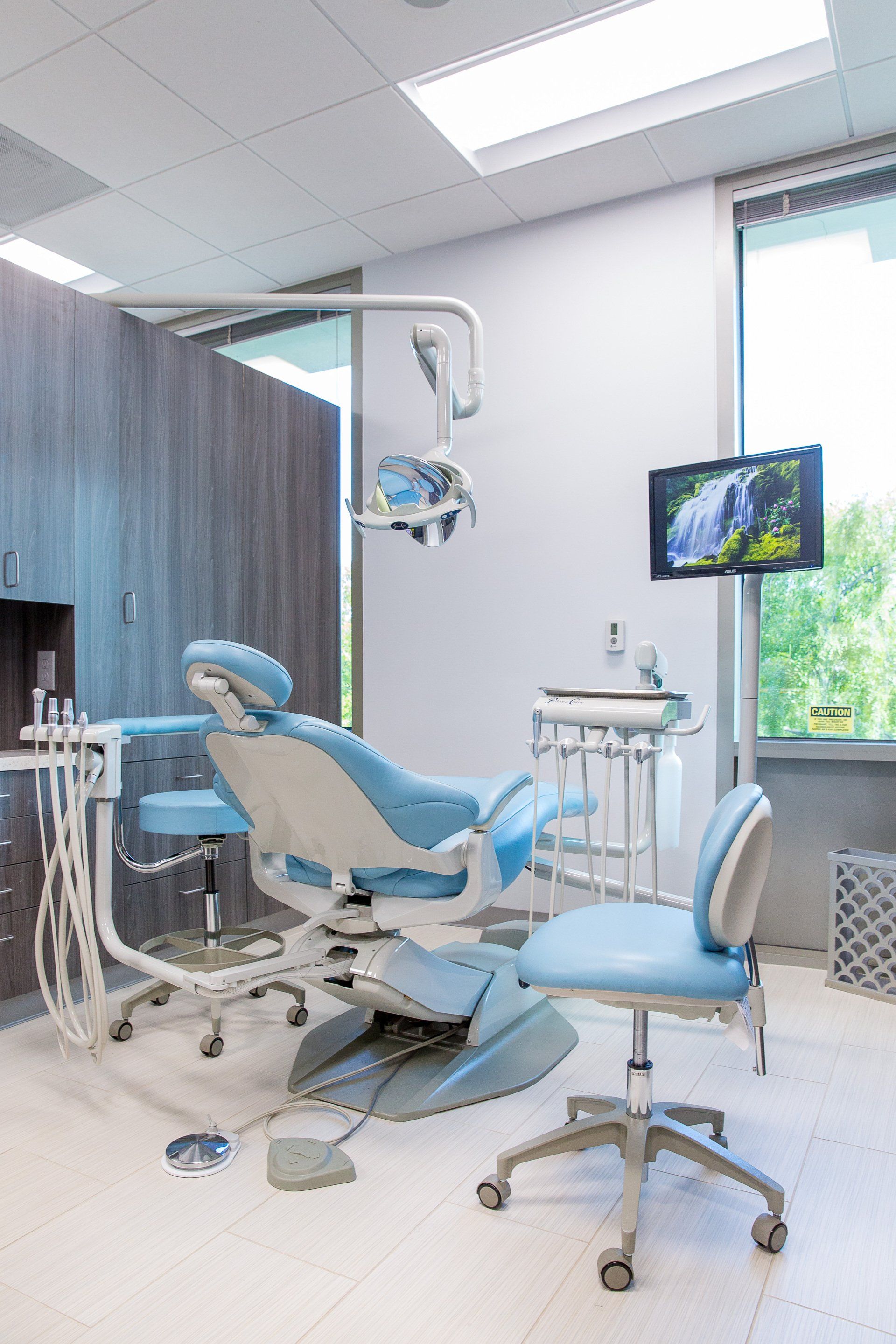 A dental office with a dental chair and a television.