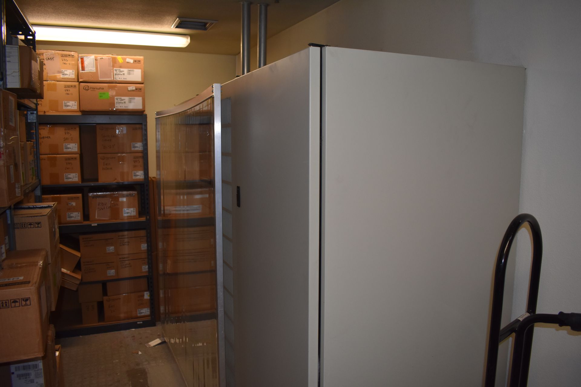A warehouse filled with lots of boxes and a cart.