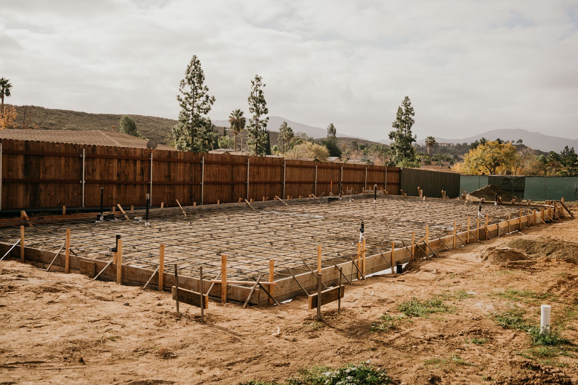 A dirt field with a wooden fence in the background