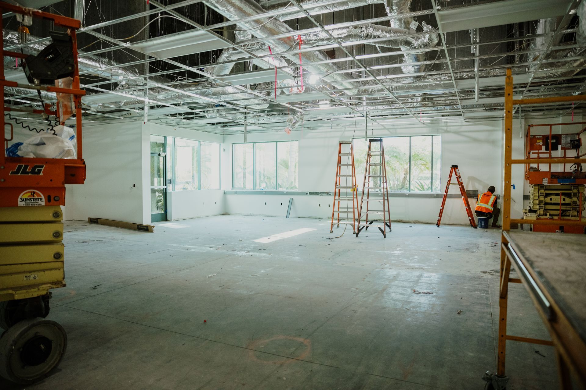 A large empty room with a ladder in the middle of it.