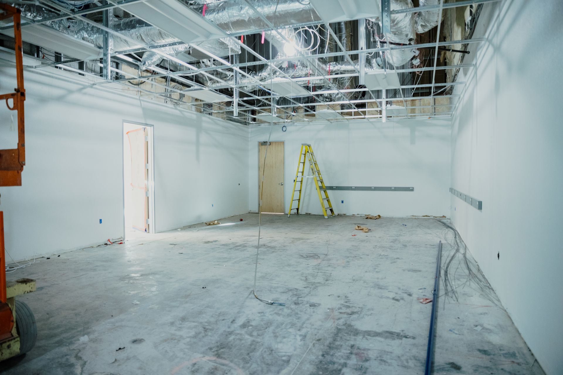 An empty room with a ladder in the middle of it.