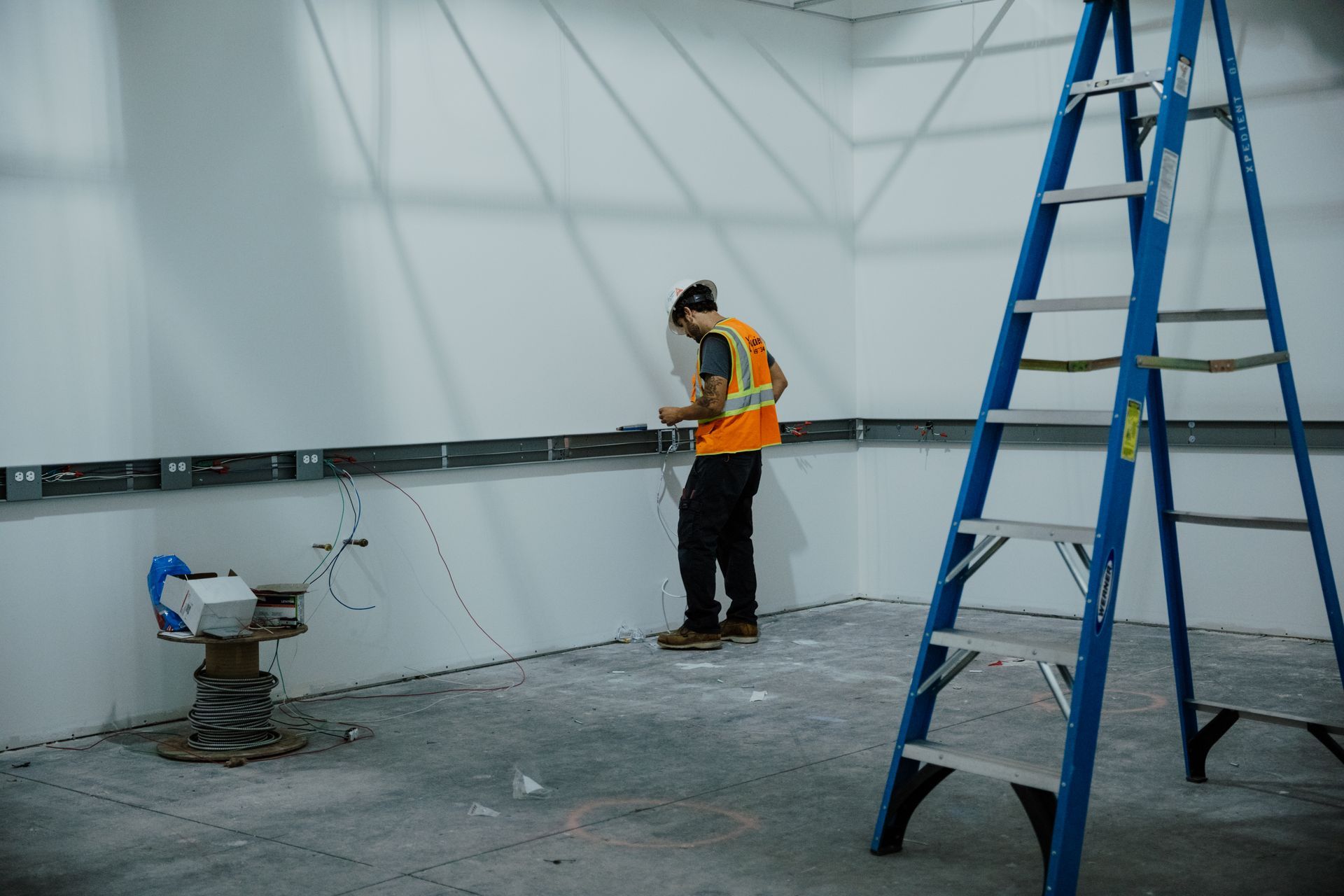 A man is standing in a room next to a ladder.
