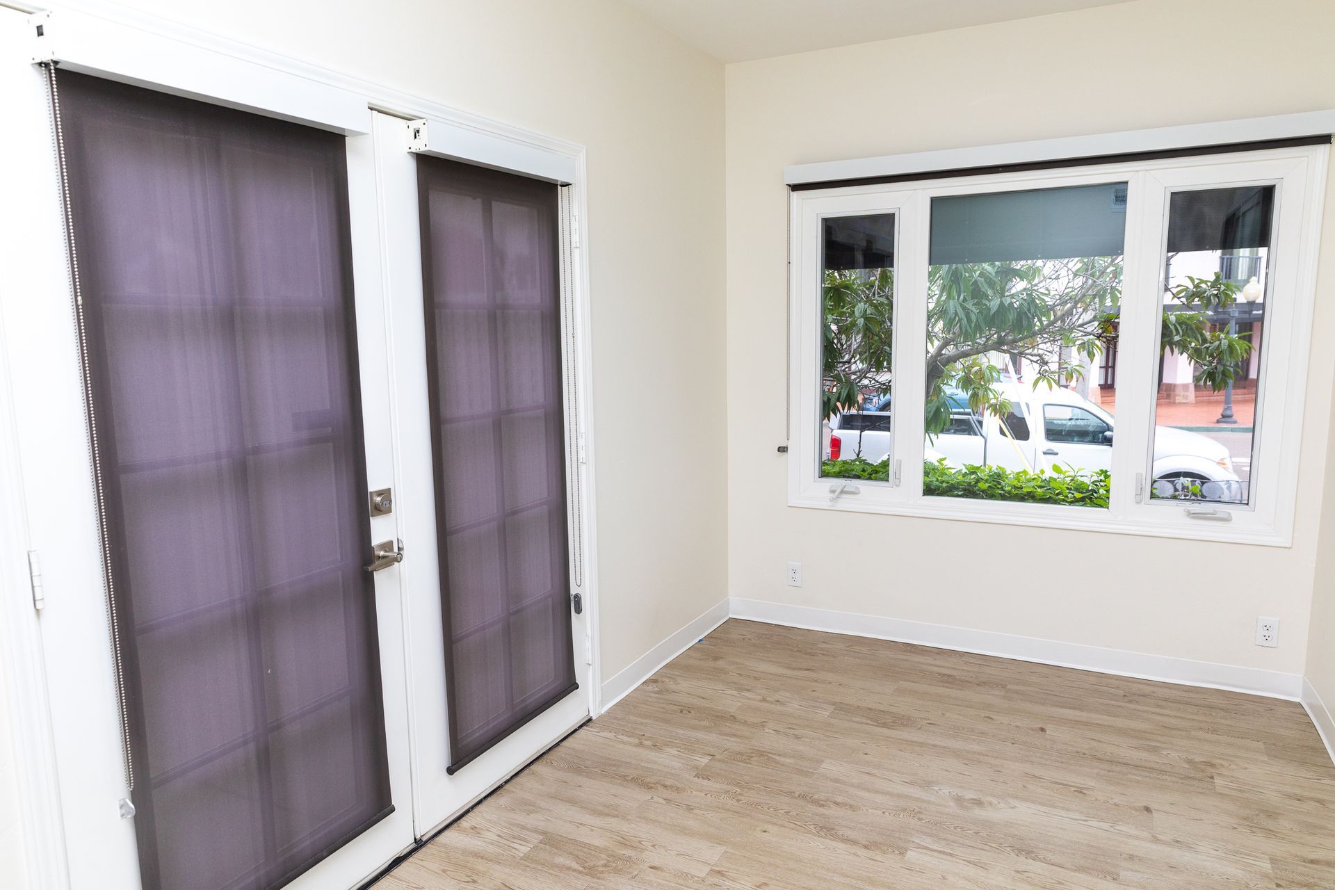 An empty room with a sliding glass door and two windows.