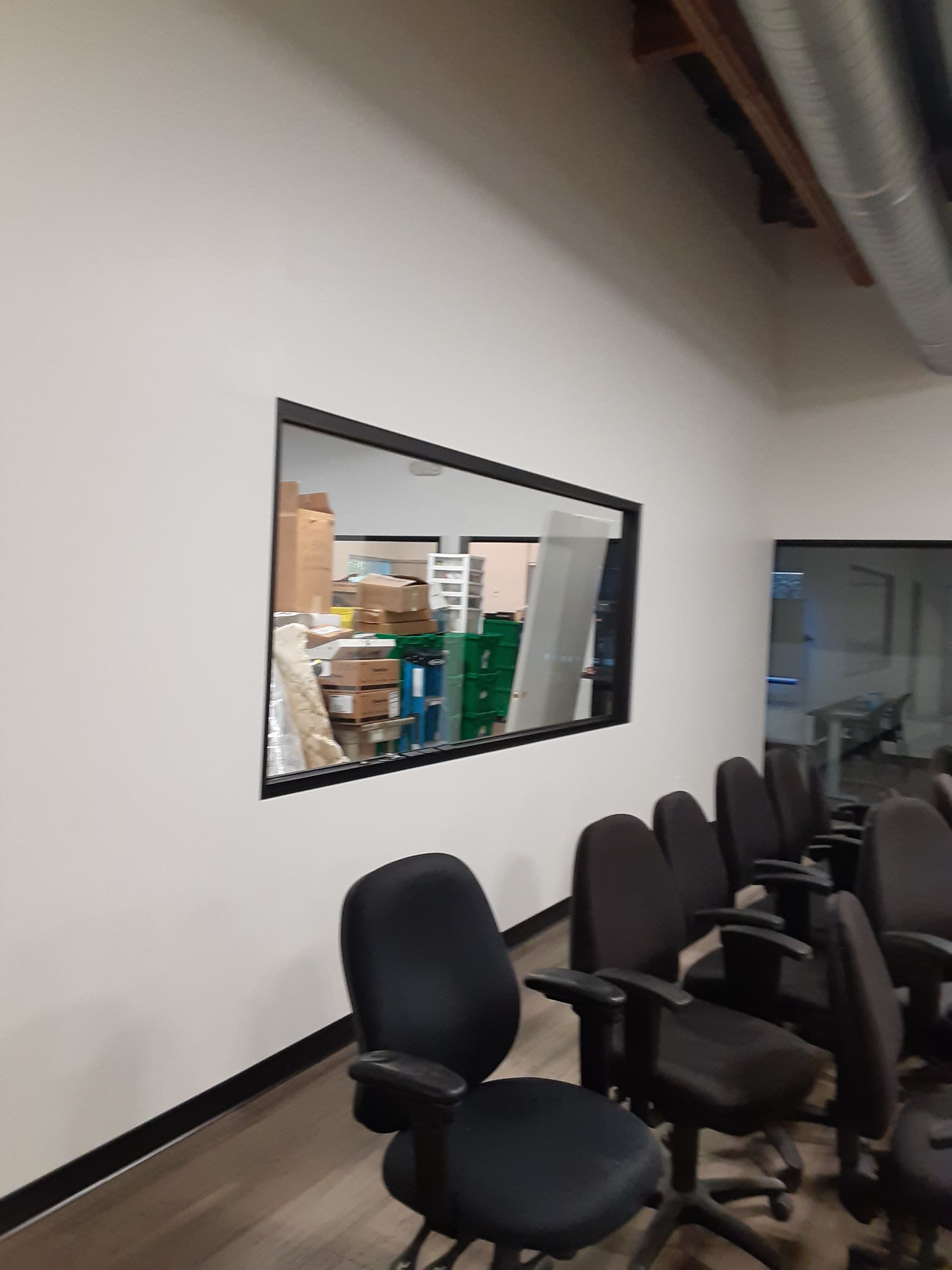 A row of office chairs in a room with a large window.