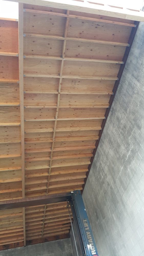 The ceiling of a building is made of wood and concrete.