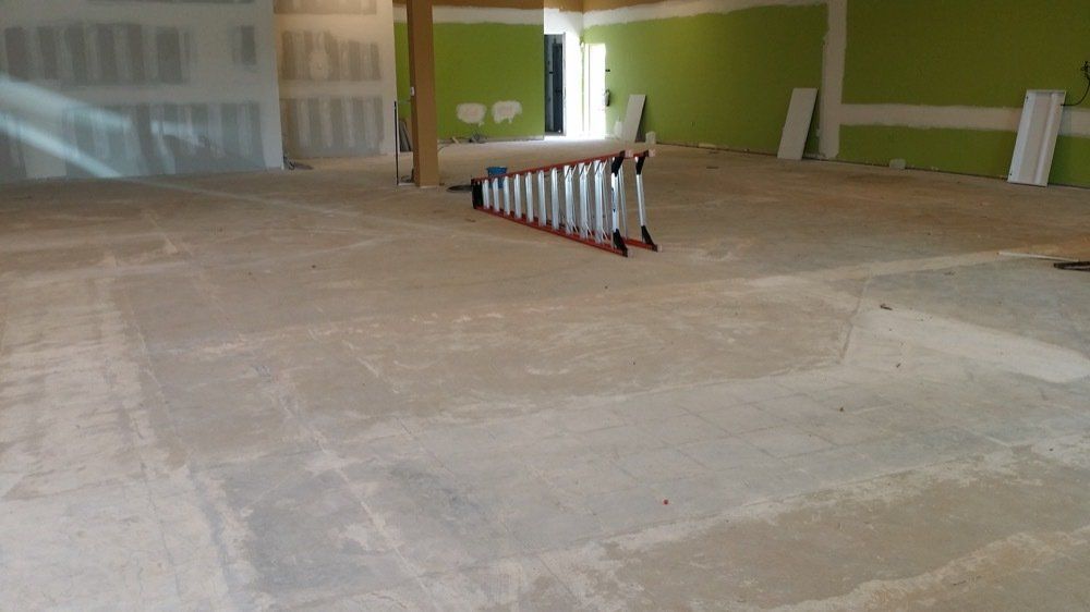 A ladder is sitting on the floor of an empty room.