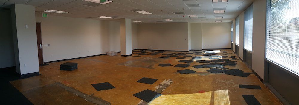 A large empty room with a lot of tiles on the floor.