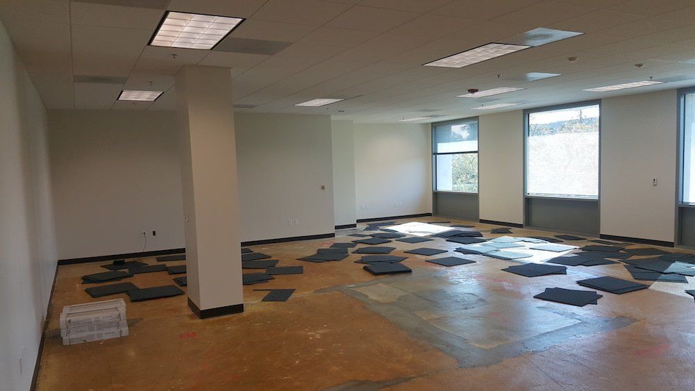 A large empty room with a lot of tiles on the floor.