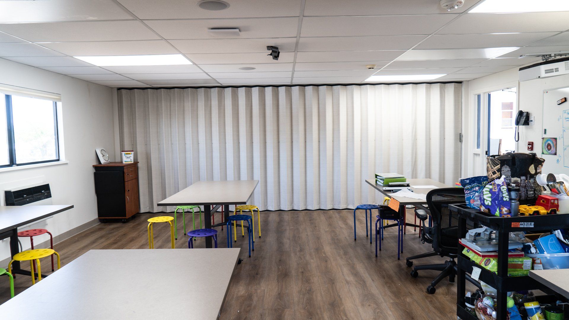 A room with tables and chairs in it and a sliding door.